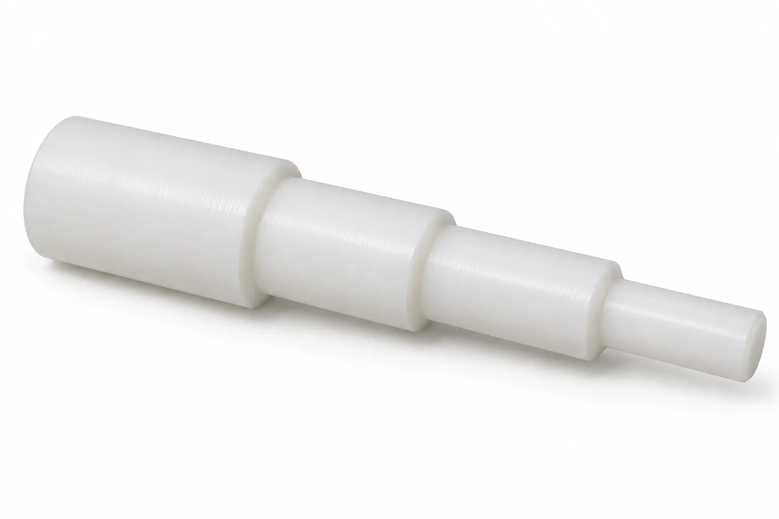 Stepped POM Shafts showing opaque acetal plastic and finished machining features on white